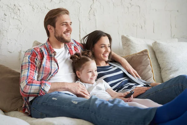 Gelukkig Gezin Met Kind Zitten Bank Kijken Jonge Ouders Omarmen — Stockfoto