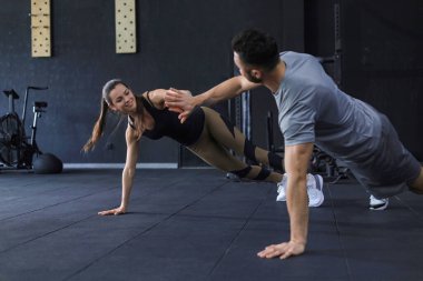 Spor yapan, şınav çeken ve spor salonunda beşlik çakan çift.