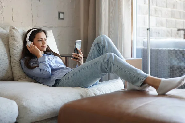 Chica Bonita Usando Teléfono Inteligente Sofá Casa Sala Estar Escuchar —  Fotos de Stock