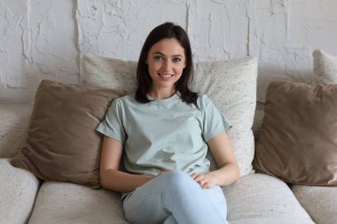 Kanepede oturan genç ve güzel bir kadın.