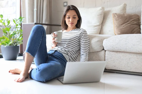 Mooie Vrouw Werken Met Laptop Terwijl Zitten Vloer Thuis Het Stockfoto