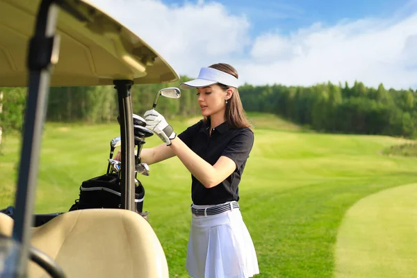 Professional woman golf player choosing the golf club from the bag