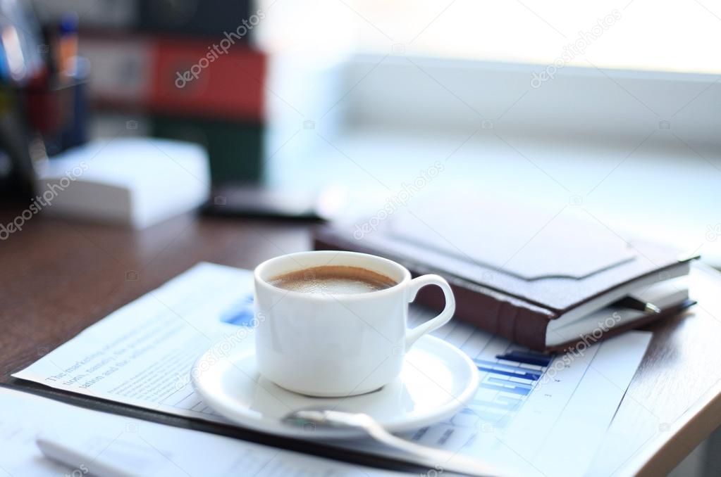 Office supplies and coffee cup on table