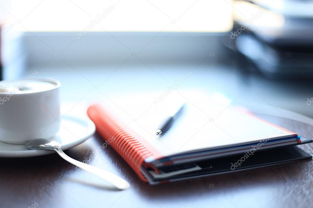 Office supplies and coffee cup on table