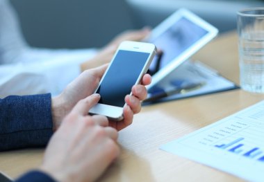 Smartphone, touchpad el closeup, arka planda çalışma arkadaşları.
