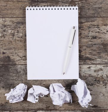 Buruşuk wads, ahşap masa üstünde defter