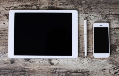 Cep telefonu, tablet bilgisayar, ahşap arka plan üzerinde kalem