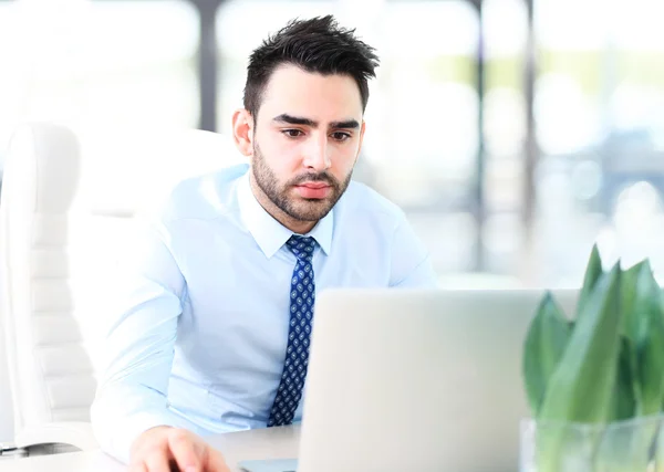 Hombre de negocios guapo que trabaja con el ordenador portátil — Foto de Stock