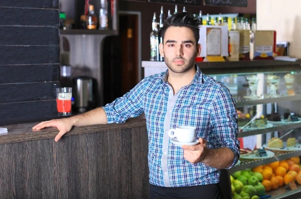 Przystojny barista oferuje kawę — Zdjęcie stockowe