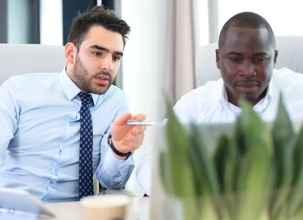Image de deux jeunes hommes d'affaires en interaction lors d'une réunion — Photo