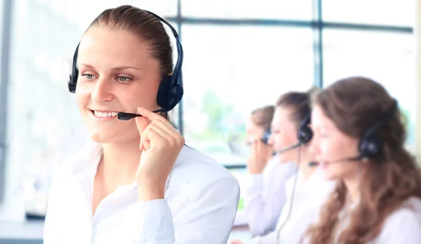 Lächelnde Kundendienstmitarbeiterin spricht auf Kopfhörer — Stockfoto