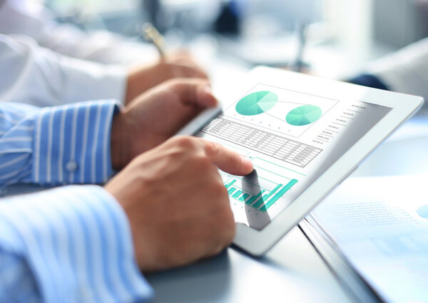 Cropped shot of a group of businesspeople looking at graphs