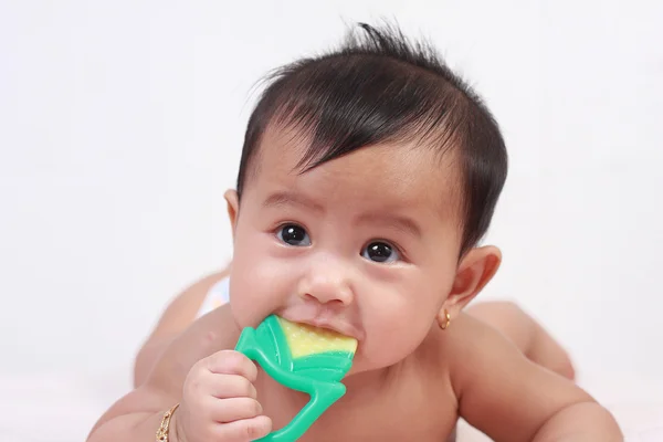 Roztomilé asijské děvčátko kousání gumové hračky — Stock fotografie