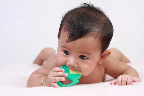 Lindo asiático bebé niña mordiendo juguete de goma —  Fotos de Stock