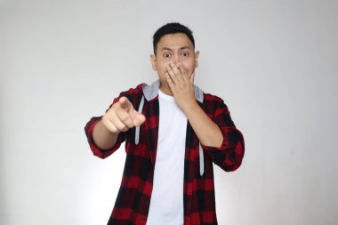 Asyalı komik bir gencin portresi kötü bir şey görmek için ileri bakıyor. Gri üzerine şok olmuş şok olmuş bir ifade.