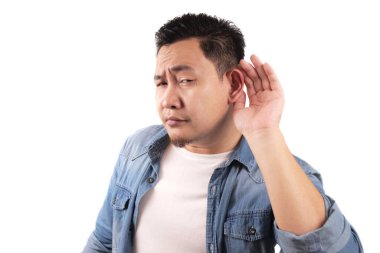 Genç Asyalı adam komik yüzlü fısıltıları dinler. Merak ettim. İlgi çekici dedikoduları dikkatle dinle. Muhabbet haberleri, gizlilik ihlali kavramı