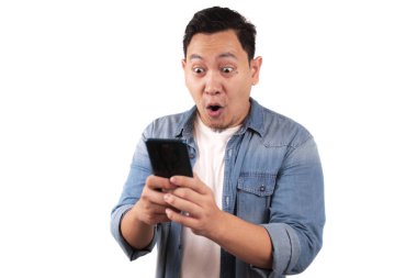 Çekici genç Asyalı adamın telefonunda güzel haberler var. Gülümseyen, gülen, kazanan bir ifade.