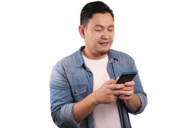 Çekici, komik, Asyalı genç adam telefonunda mesajlaşarak gülüyor, gülüyor.