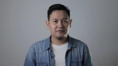 Asyalı genç bir adamın portresi baş parmak işareti, mutlu gülümseyen kişi, tamam anlaşma konsepti