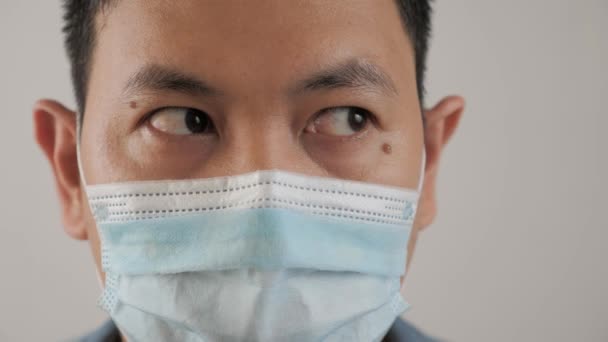 Homme portant un masque facial protecteur. Ses yeux regardant côte à côte, expression nerveuse et inquiète — Video