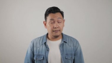 Genç Asyalı adam kulaklarını kapatıyor. Kötü haber duymak ya da duymaktan kaçınmak istemiyor. Zihinsel baskı altında stres. 