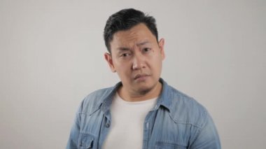 Genç Asyalı adam komik yüzlü fısıltıları dinler. Merak ettim. İlgi çekici dedikoduları dikkatle dinle. Muhabbet haberleri, gizlilik ihlali 