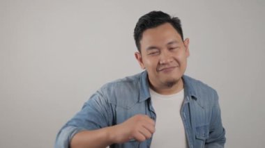 Komik, genç Asyalı adam mutlu bir şekilde dans ediyor. Mutlu haberi veriyor. Zaferi kutluyor. 