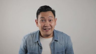 Asyalı adam gülümsüyor ve mutlu bir şekilde dans ediyor, neşeli bir şekilde iyi haberi kutluyor zafer kazanıyor başarı jesti.