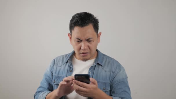 Vonzó fiatal ázsiai férfi olvas SMS chat a telefonján, rossz hír, szomorú sírás kifejezés — Stock videók