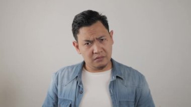 Omuz silkme hareketi yapan genç Asyalı adam, bilmiyorum ya da reddedildiğini gösteriyor.