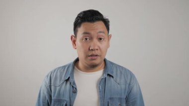 Asyalı genç adamın portresi üzgün bir ifade sergiliyor.