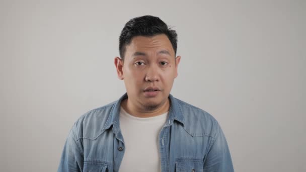 Portrait young asian man shows upset expression with thumbs down — Stok Video