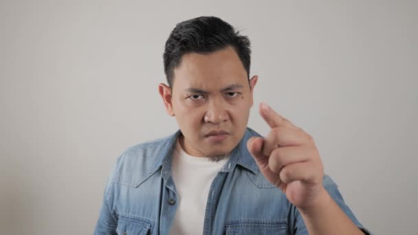 アジアの男の肖像画は、前方を指している皮肉な不幸な怒っている顔の表情を示す、警告を与える — ストック動画