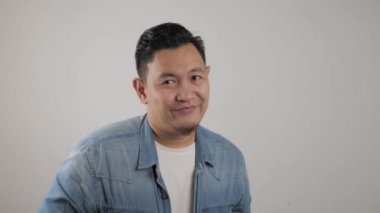 Komik Asyalı genç bir adamın portresi. Kocaman ağzıyla çok gülüyor.