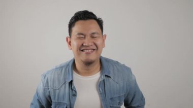 Komik Asyalı genç bir adamın portresi. Kocaman ağzıyla çok gülüyor.