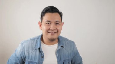 Kameraya gülümseyen başarılı Asyalı genç adam. Kendine güvenen, iyi görünümlü, pozitif biri.