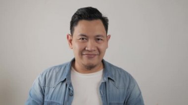 Kameraya gülümseyen başarılı Asyalı genç adam. Kendine güvenen, iyi görünümlü, pozitif biri.