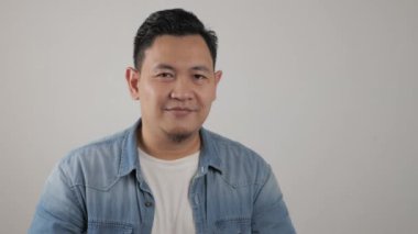 Kameraya gülümseyen başarılı Asyalı genç adam. Kendine güvenen, iyi görünümlü, pozitif biri.