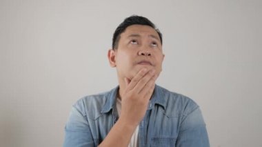 Asyalı adam ciddi bir şey düşünüyor. Üzücü bir düşünce jesti.