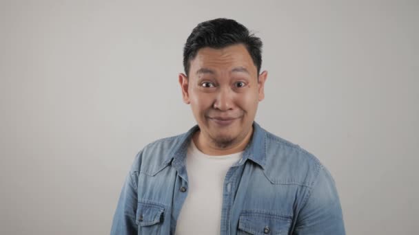 Porträt von lustigen jungen attraktiven netten asiatischen Mann lächelt schüchtern glücklich, — Stockvideo