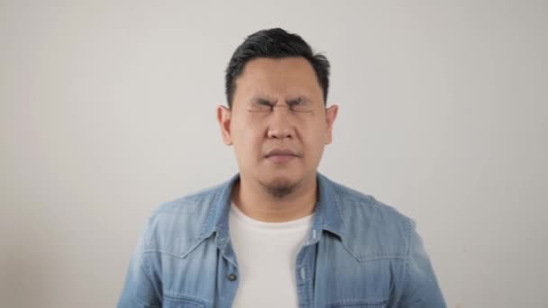 Portret van jonge Aziatische man keek verwarrend en bang voor iets slechts — Stockvideo