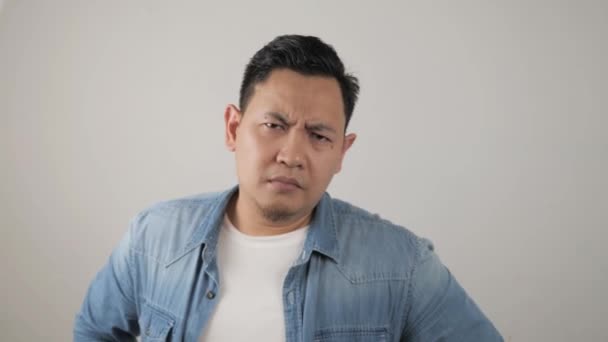 Portret van jonge Aziatische man tonen cynische ongelukkig boze gezichtsuitdrukking, kijken naar camera met argwaan blik, — Stockvideo