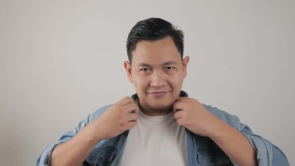 Schöner asiatischer Mann trägt Jeansjacke an und lächelt in die Kamera, fröhlicher selbstbewusster Ausdruck, — Stockvideo