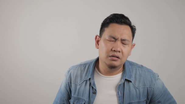 Asiatisk man tittar på kameran med sorg och ånger uttryck, besviken upprörd gest — Stockvideo