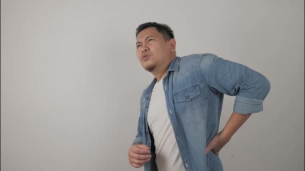 Ung asiatisk man med smärta i nedre delen av ryggen — Stockvideo