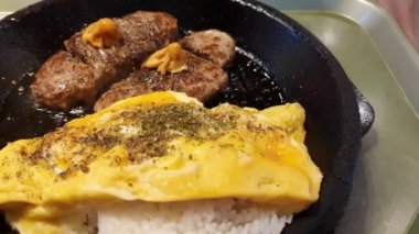 Kremalı peynirli körili omlet pirinçli bulgogi bifteği ya da sıcak tabakta hamburger köftesi, Asya mutfağı.