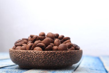 Fotokopi alanı olan ahşap bir kasede kavrulmuş kahve çekirdekleri.