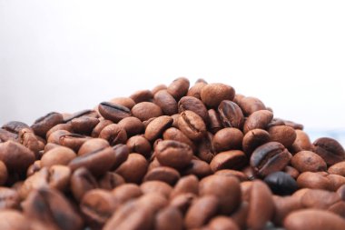 Kızarmış kahve çekirdekleri beyaz arka planda izole edilmiş. 