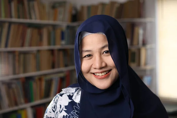 幸せな美しいアジアのイスラム教徒の女性は カメラに笑みを浮かべてヒジャーブを身に着けています 図書館の女性学生 クローズアップ — ストック写真