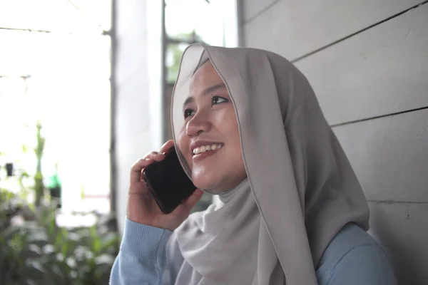 幸せなアジアのイスラム教徒の女性は彼女の家の外で電話で話して 幸せな陽気な表情を笑って — ストック写真